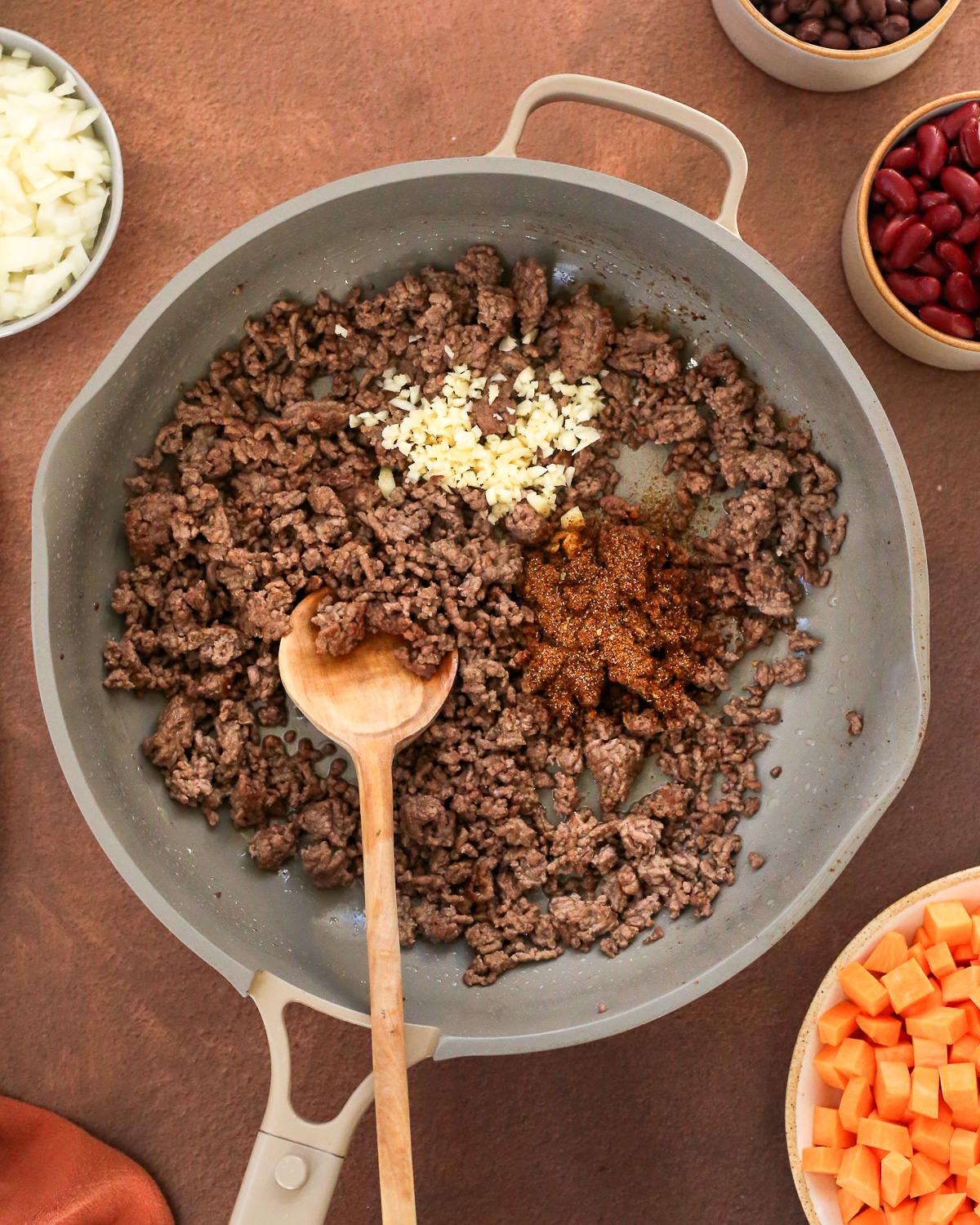 A large nonstick skillet containing browned ground beef.