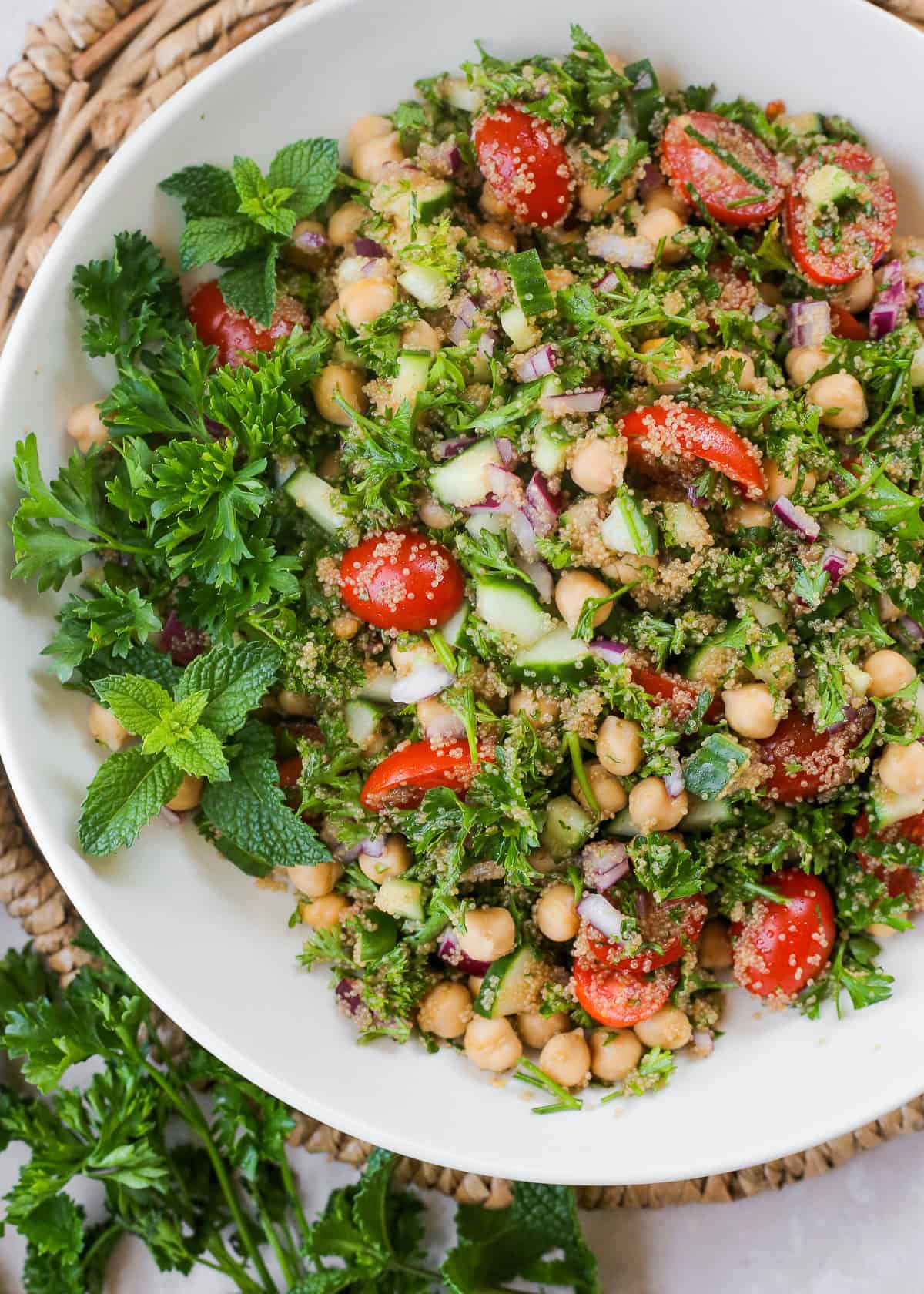 Overhead view of amaranth tabbouleh with chickpeas in a white ceramic serving bowl.
