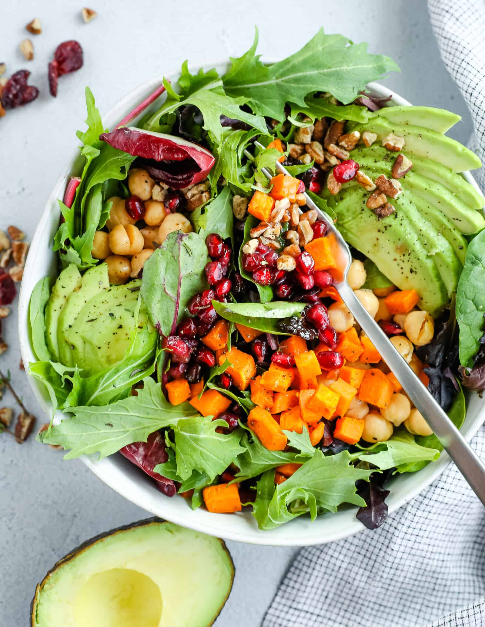 Colorful vegan pomegranate salad with creamy pomegranate dressing and avocado