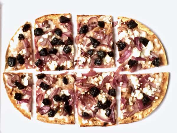 A Cheesy Dried Plum Flatbread sliced into small squares