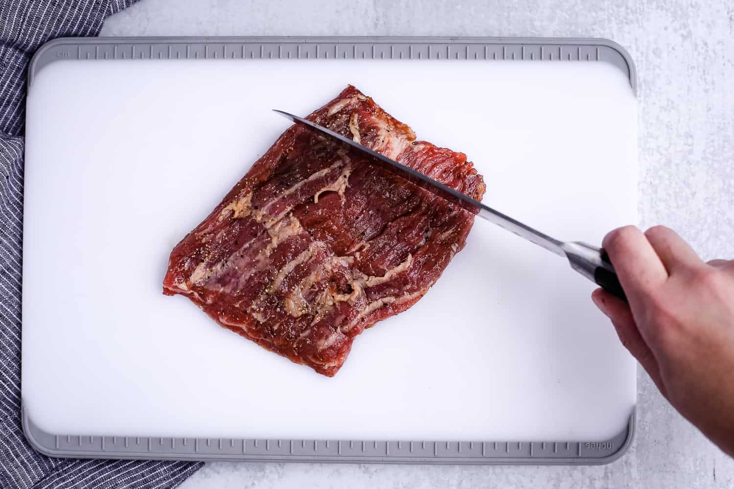 Cutting a skirt steak against the grain for a tender texture