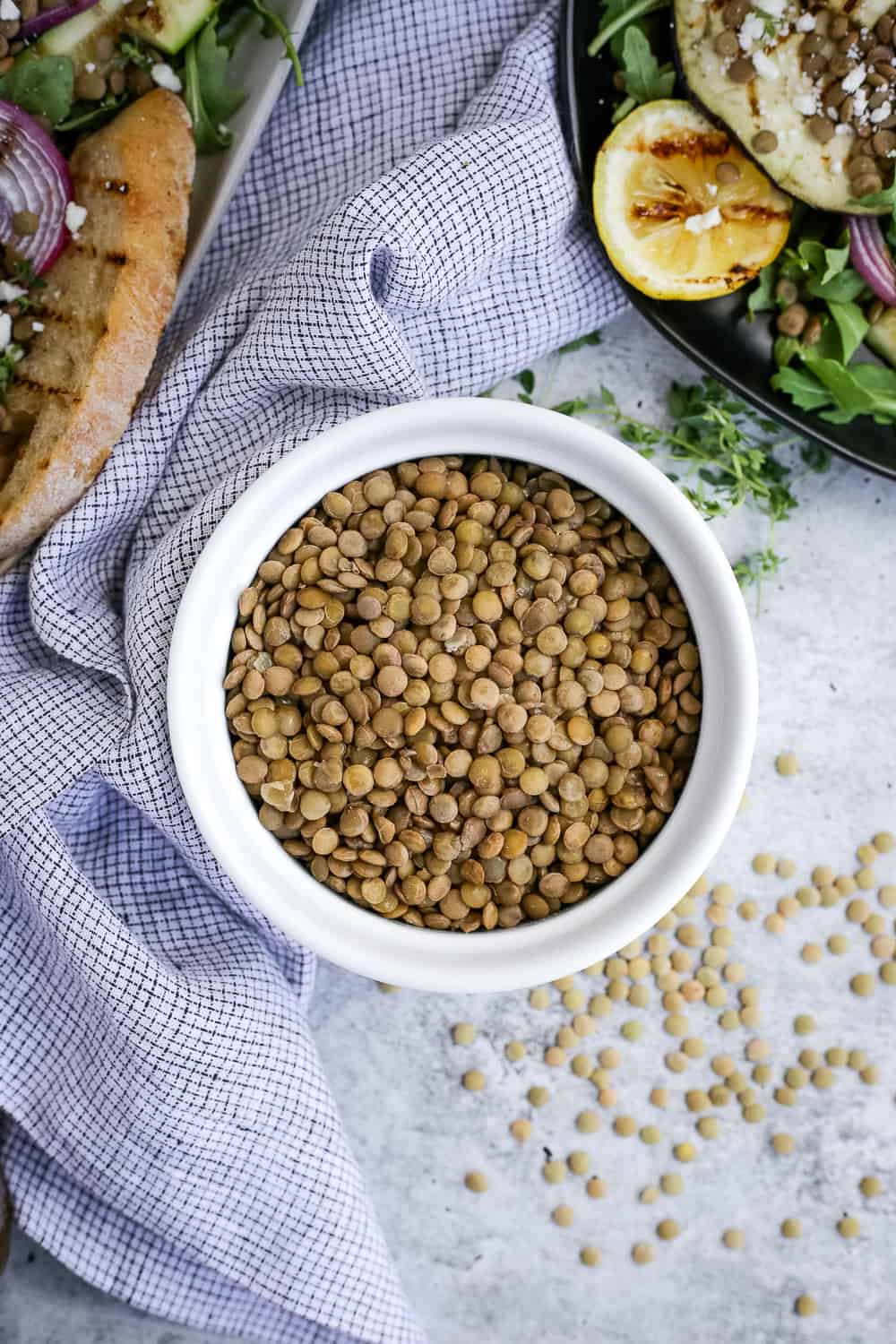 Overhead view of cooked brown lentils in a small white ramekin