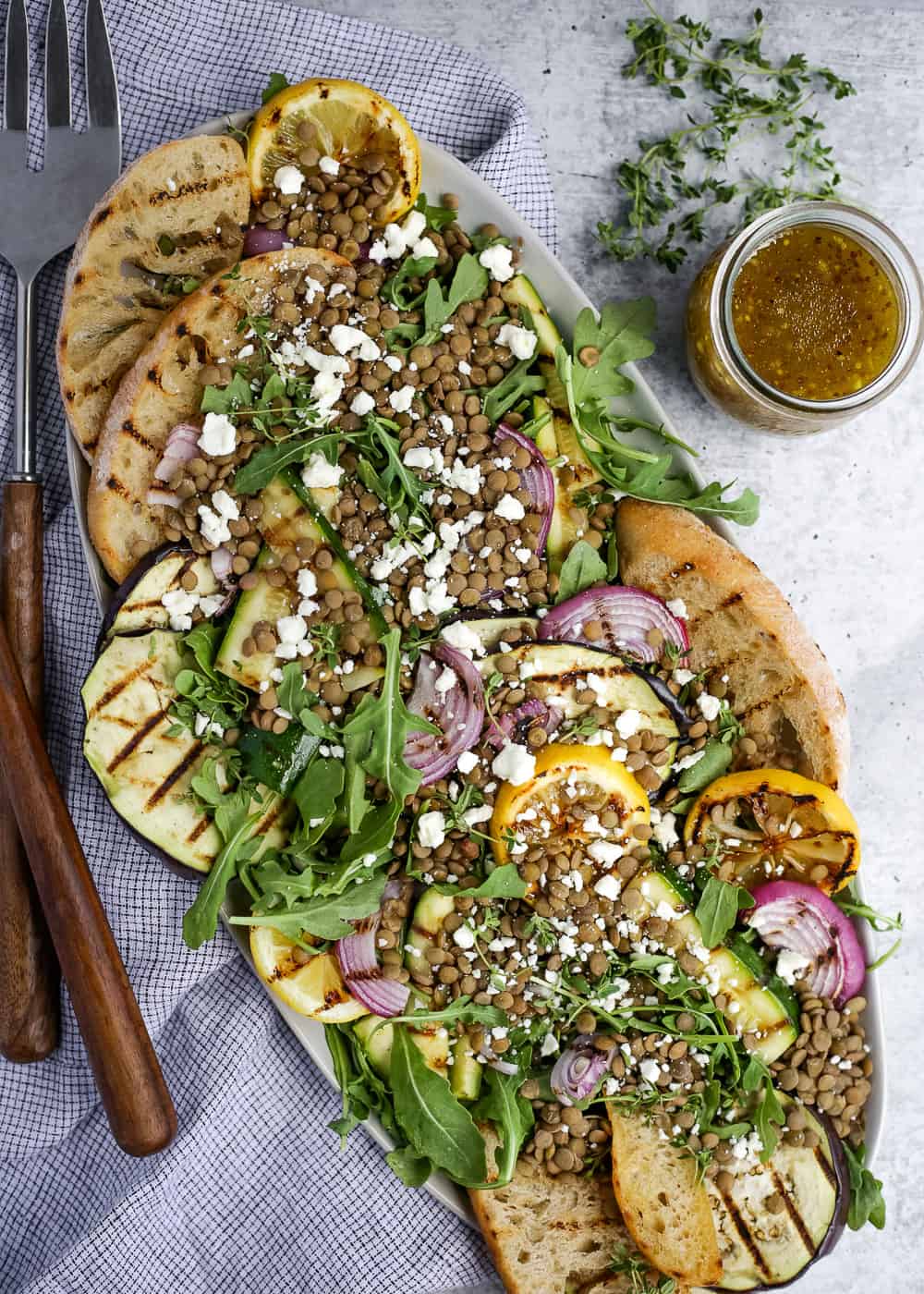 Overhead view of the serving platter with the Green Salad with Lentils recipe, appearing colorful and freshly grilled 