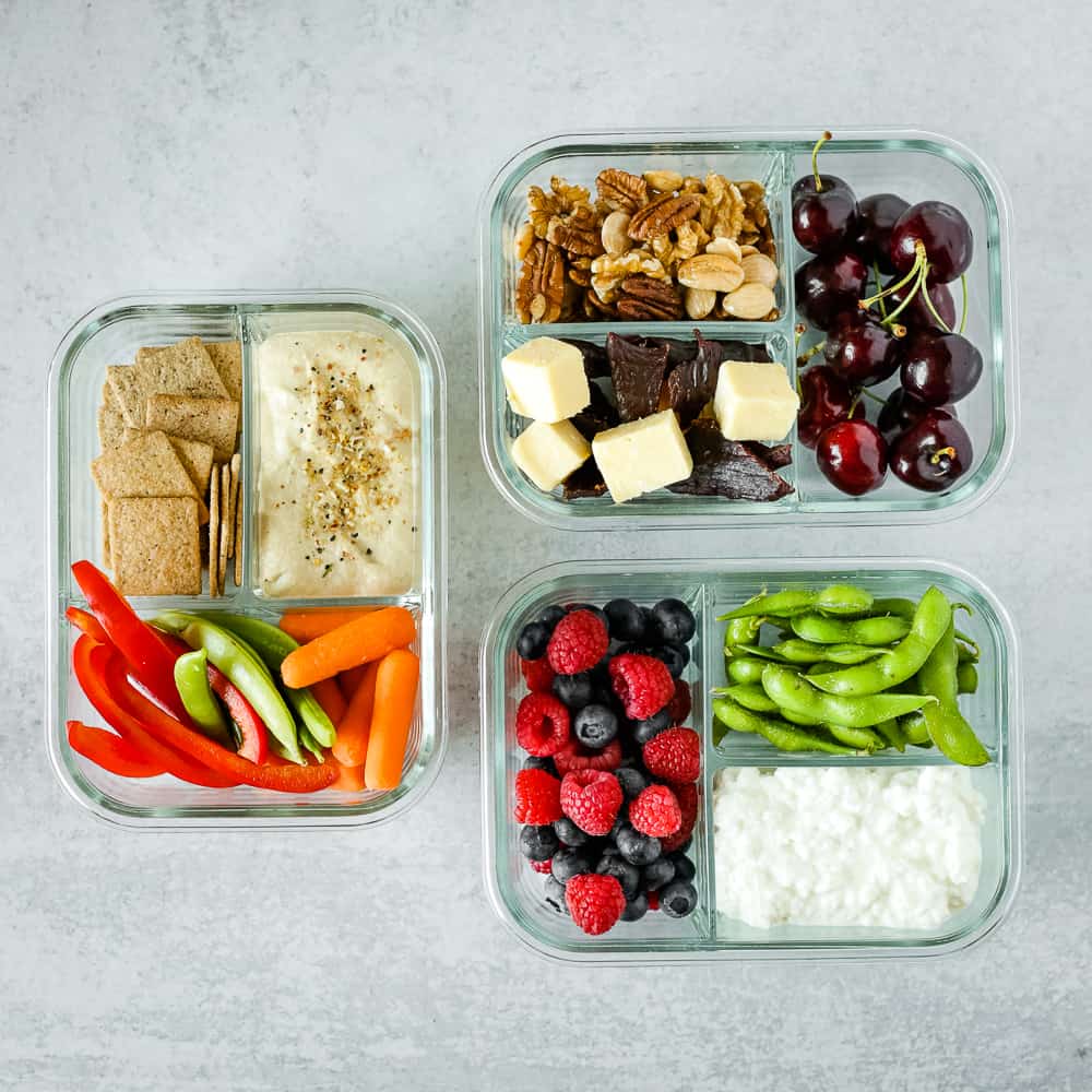 Three versions of snack meals prepped in glass storage containers
