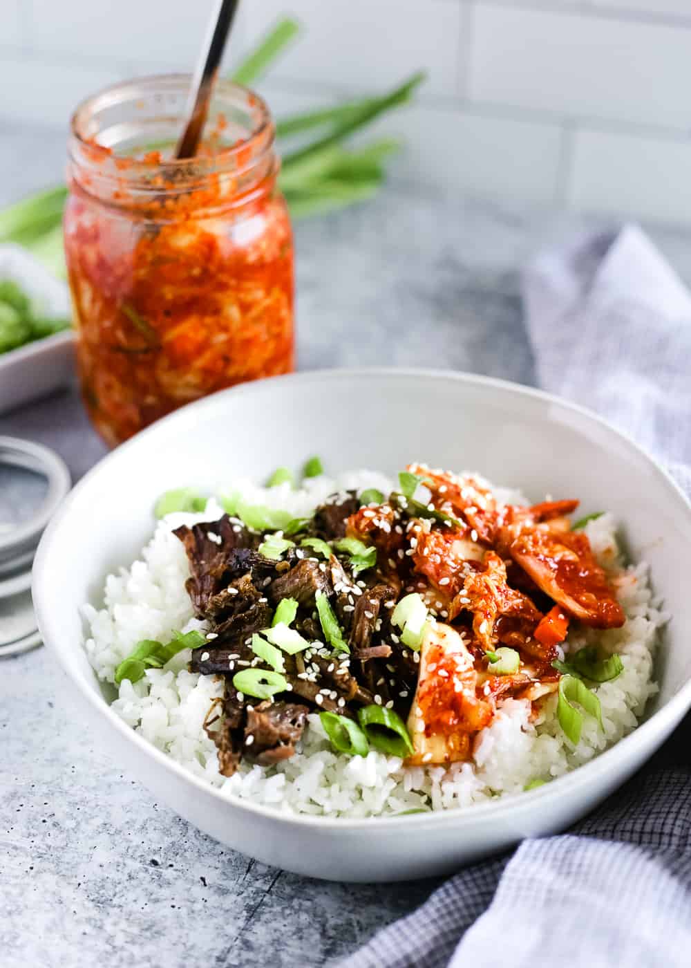 Korean beef and rice bowls in a white bowl on a kitchen countertop