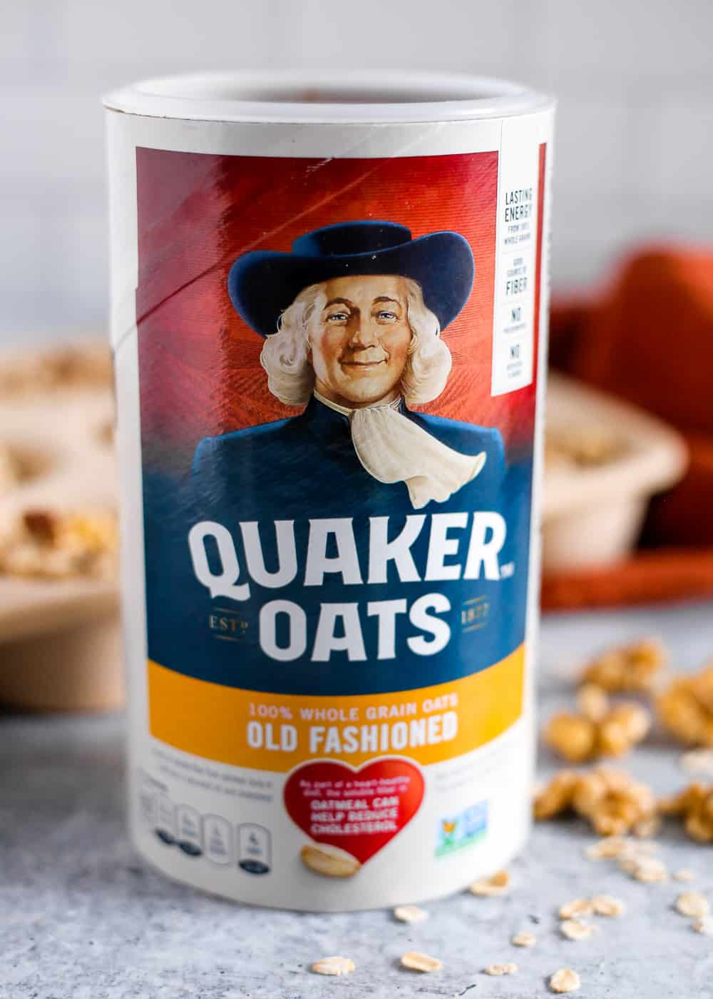 A canister of Quaker Old Fashioned Oats on a kitchen counter with a muffin tin in the background