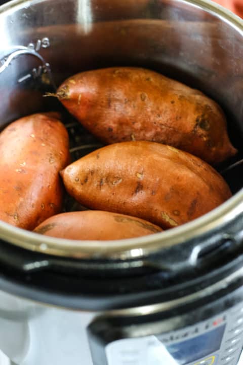 Four sweet potatoes inside an Instant Pot