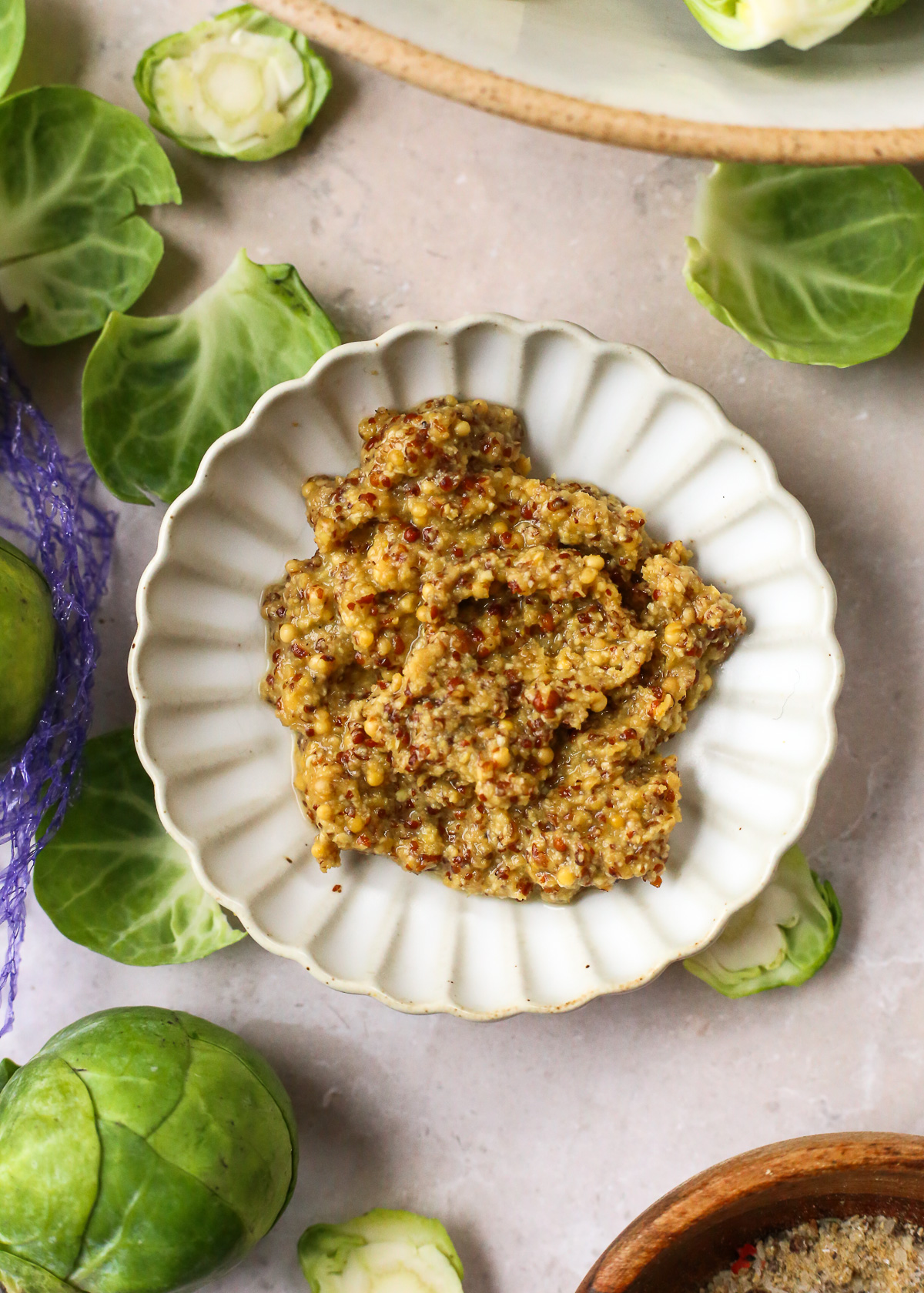 A close view of stone ground or whole grain mustard in a small prep bowl. 