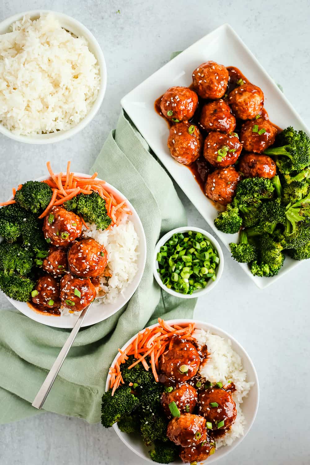 Overhead view of glazed spicy turkey meatballs with rice bowls, roasted broccoli, and sliced green onions