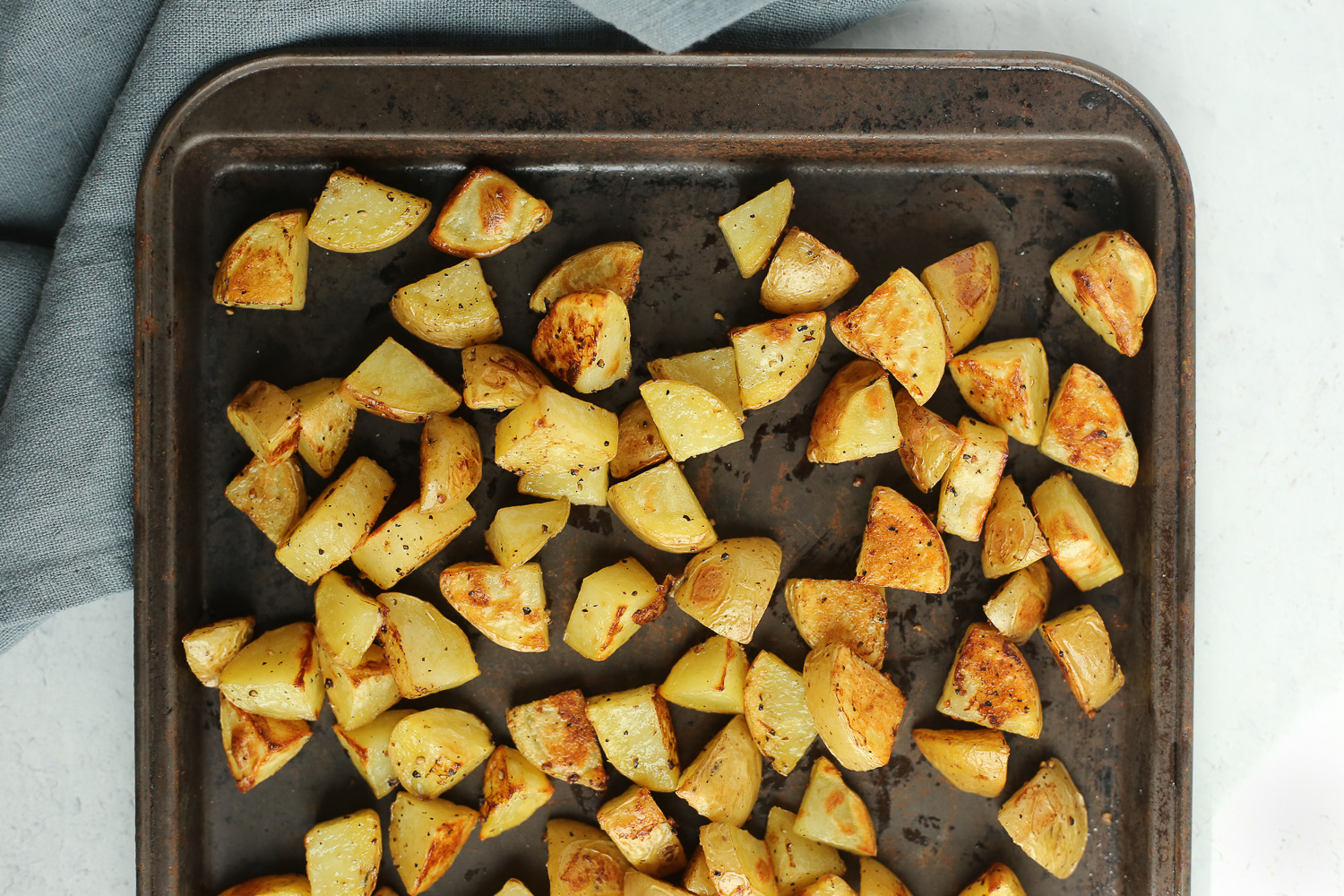 An overhead view of a sheet pan with roasted potatoes 