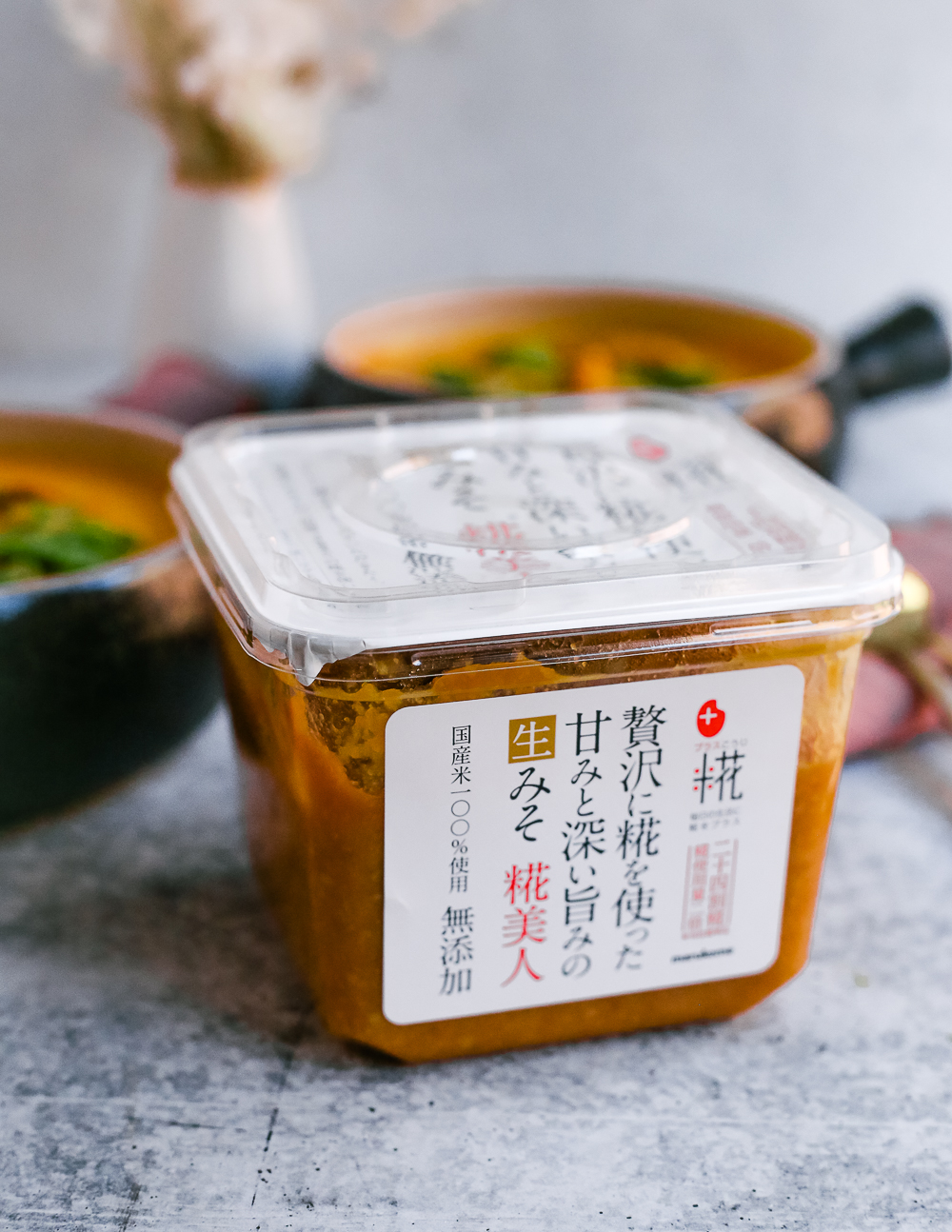 An ingredient shot of miso for this slow cooker miso soup recipe with bowls of the butternut squash and sweet potato soup in the background