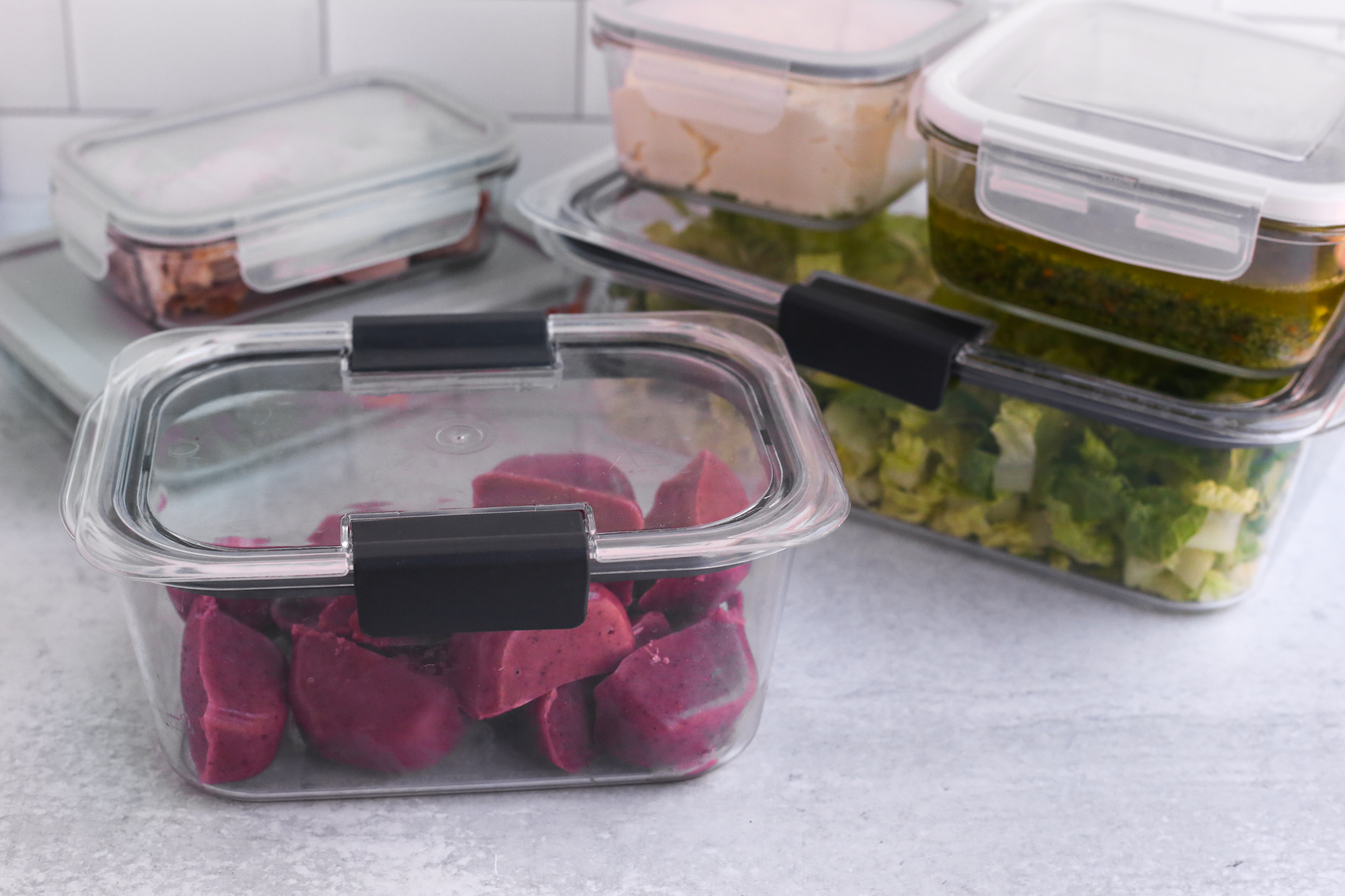 Plastic containers on a kitchen countertop with some simple meal prep ideas for busy schedules