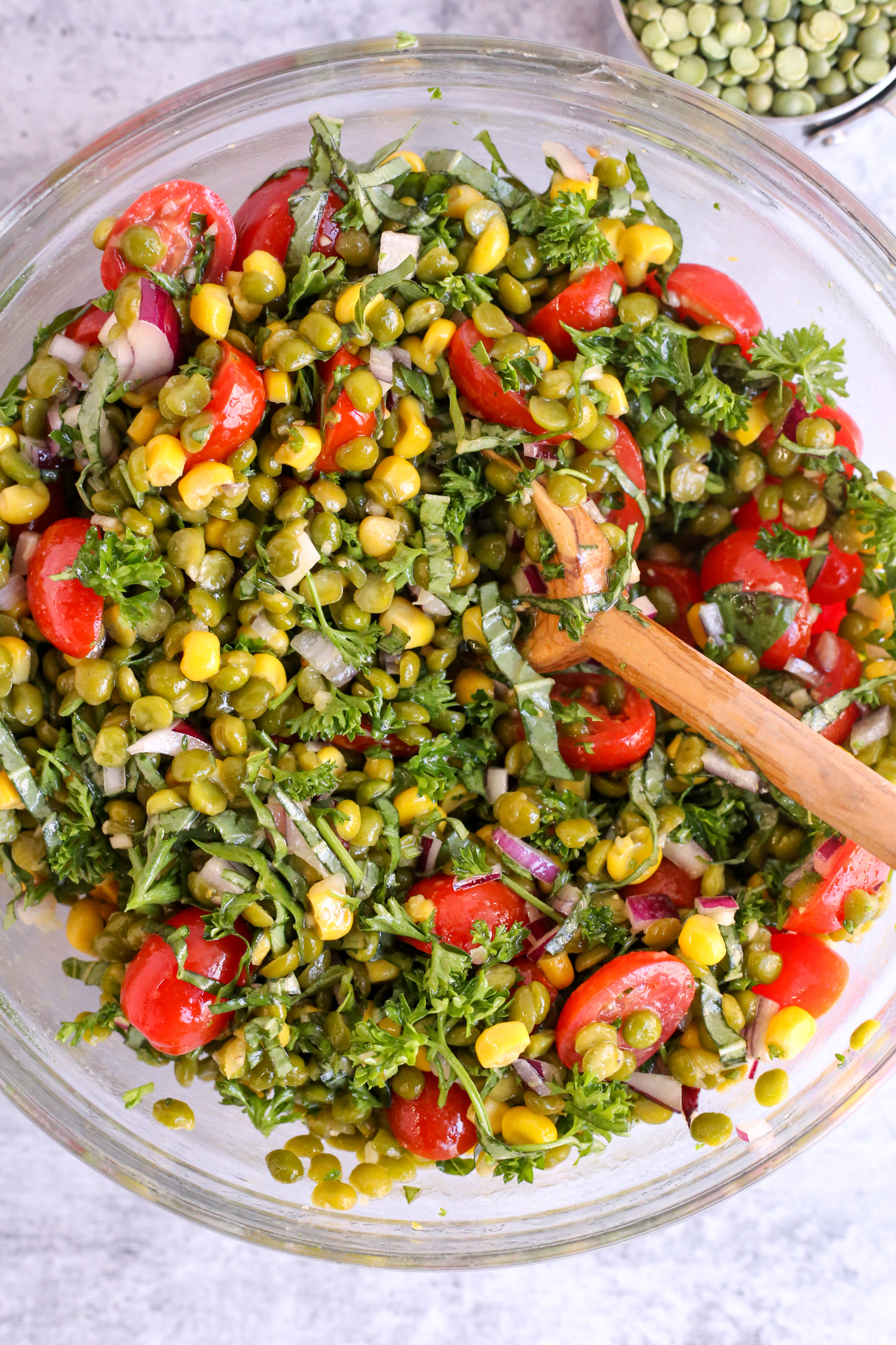 Large glass mixing bowl filled with a summer split pea salad recipe