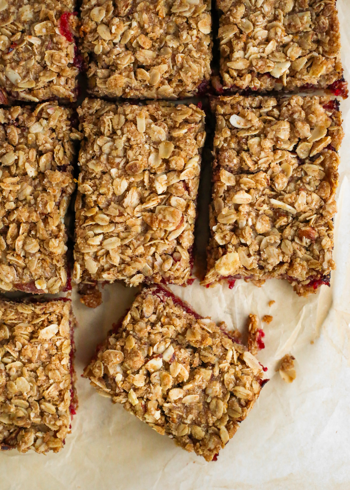 Orange Cranberry Oat Bars, cut into rectangles, arranged on parchment paper