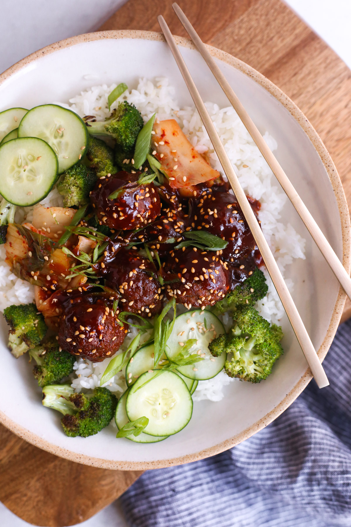 overhead view of gochujang meatballs served in a rice bowl with a pair of chopsticks