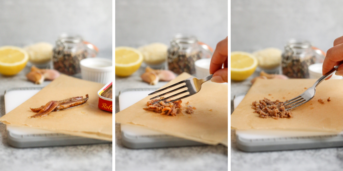 A three image series showing the steep by step process to make your own anchovy paste from anchovy fillets by mashing them with a fork on a cutting board lined with parchment paper. A woman's hand holds a silver fork with extra ingredients scattered in the background of a kitchen scene