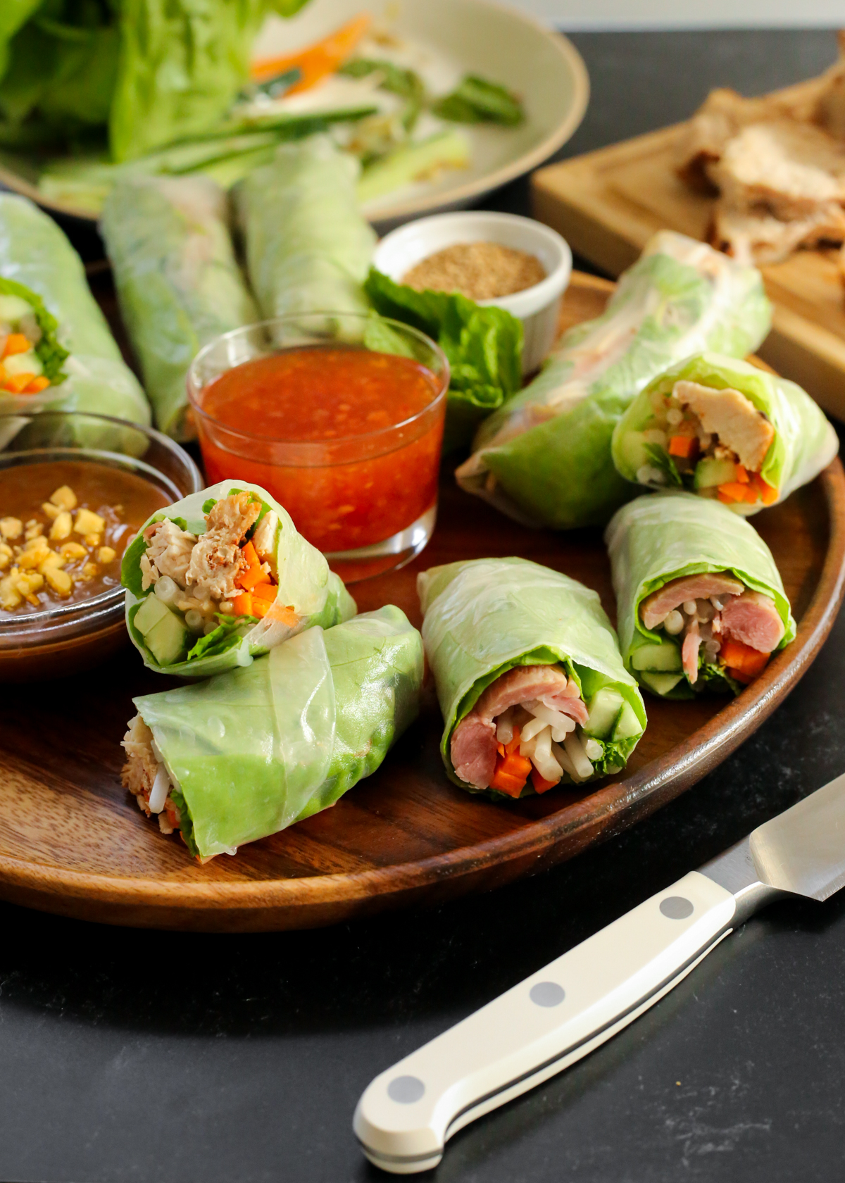 Angled view of the turkey spring rolls displayed on a serving tray long with two dipping sauces served in small glass ramekins
