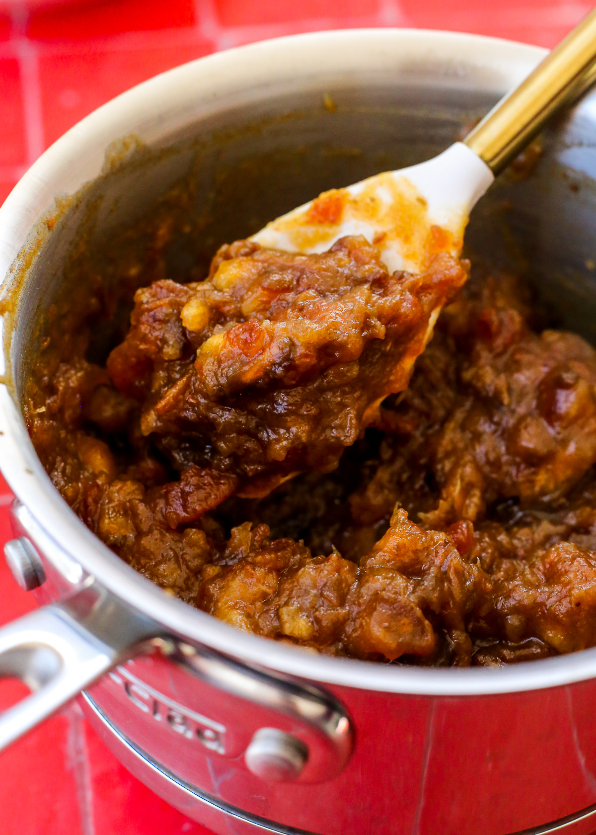 After cooking down, a spatula lifts a scoop of the date filling mixture to show its thick, chunky texture.
