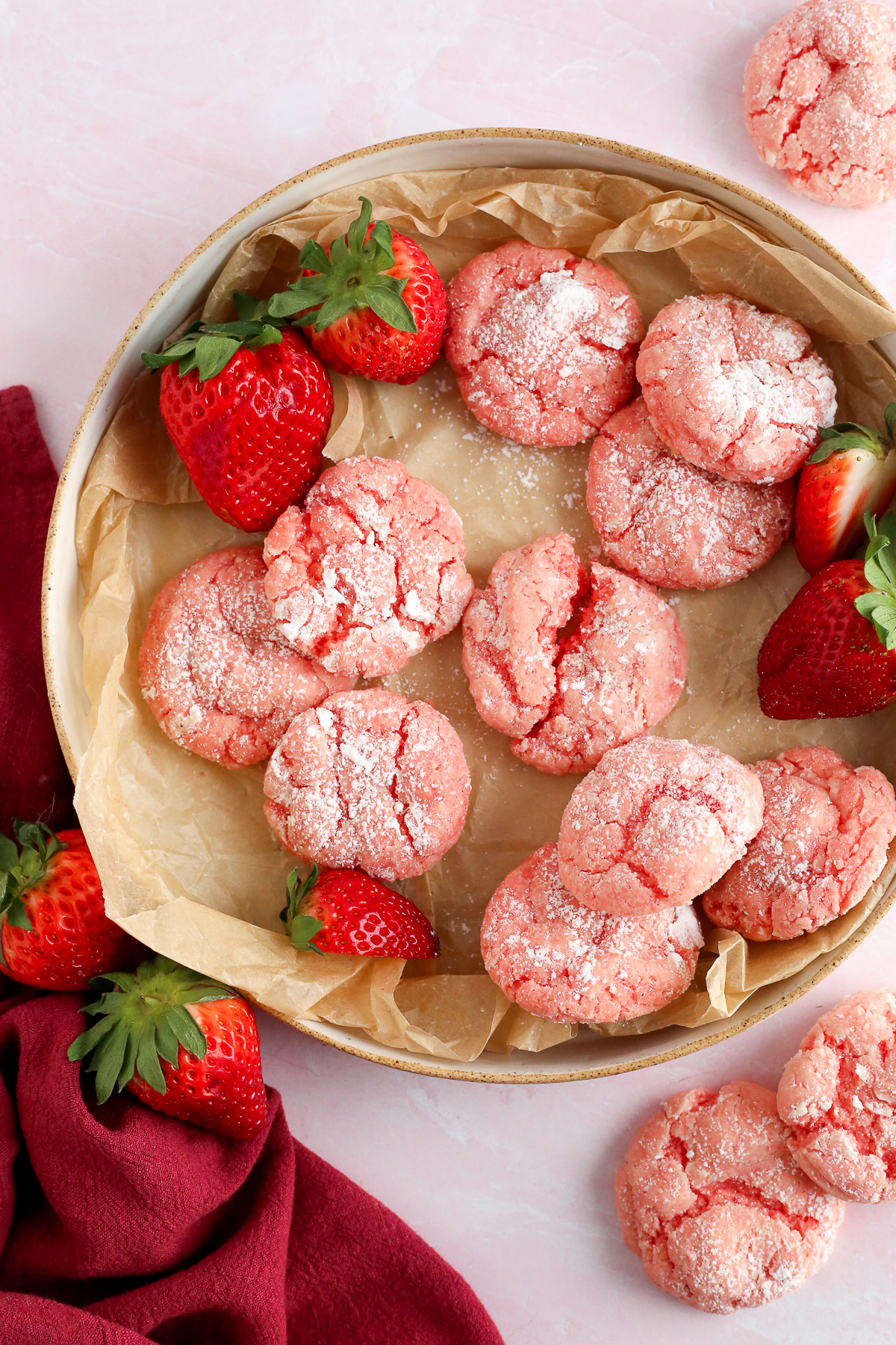 A serving tray filled with strawwberry gooey butter cookies and fresh strawberries.