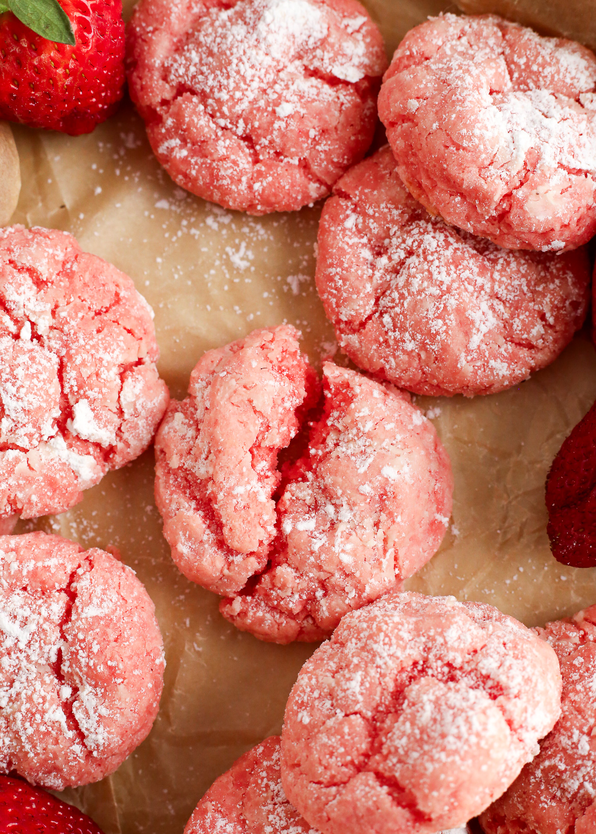 A close view of freshly baked strawberry gooey butter cookies, lightly dusted with powdered sugar.